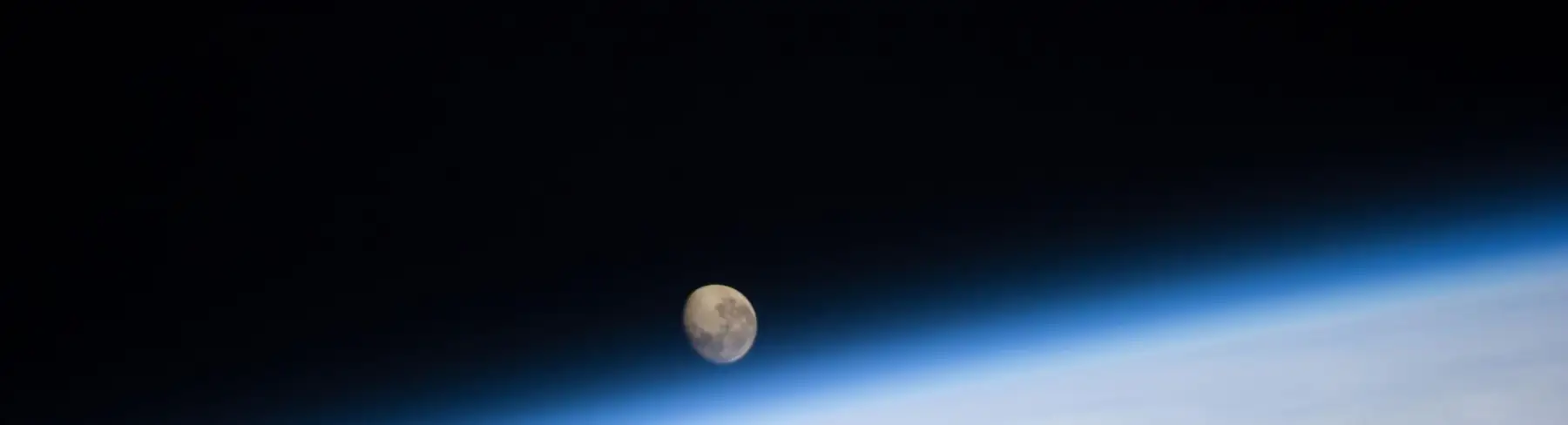 De maan boven de dampkring van de aarde, gezien vanuit het ruimtestation ISS